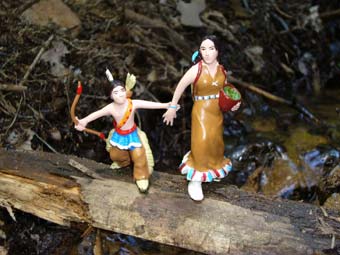 Vorsichtig überqueren die Indianerin und der Indianerjunge den Fluss